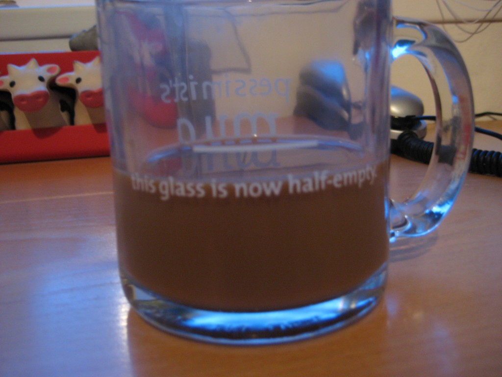 Coffee cup with a 'this glass is half empty' measure on it