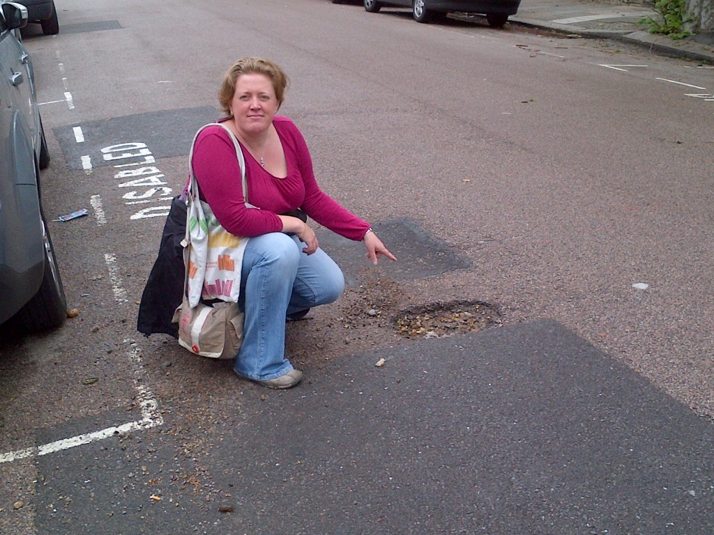 Dawn Barnes in Haringey pointing at a pothole