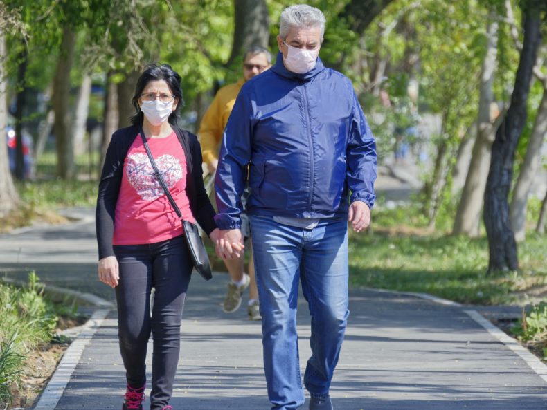 A couple walking wearing masks